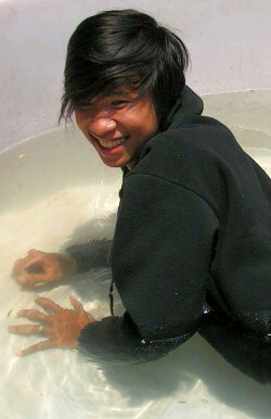 Black onesie in pool with a big smile